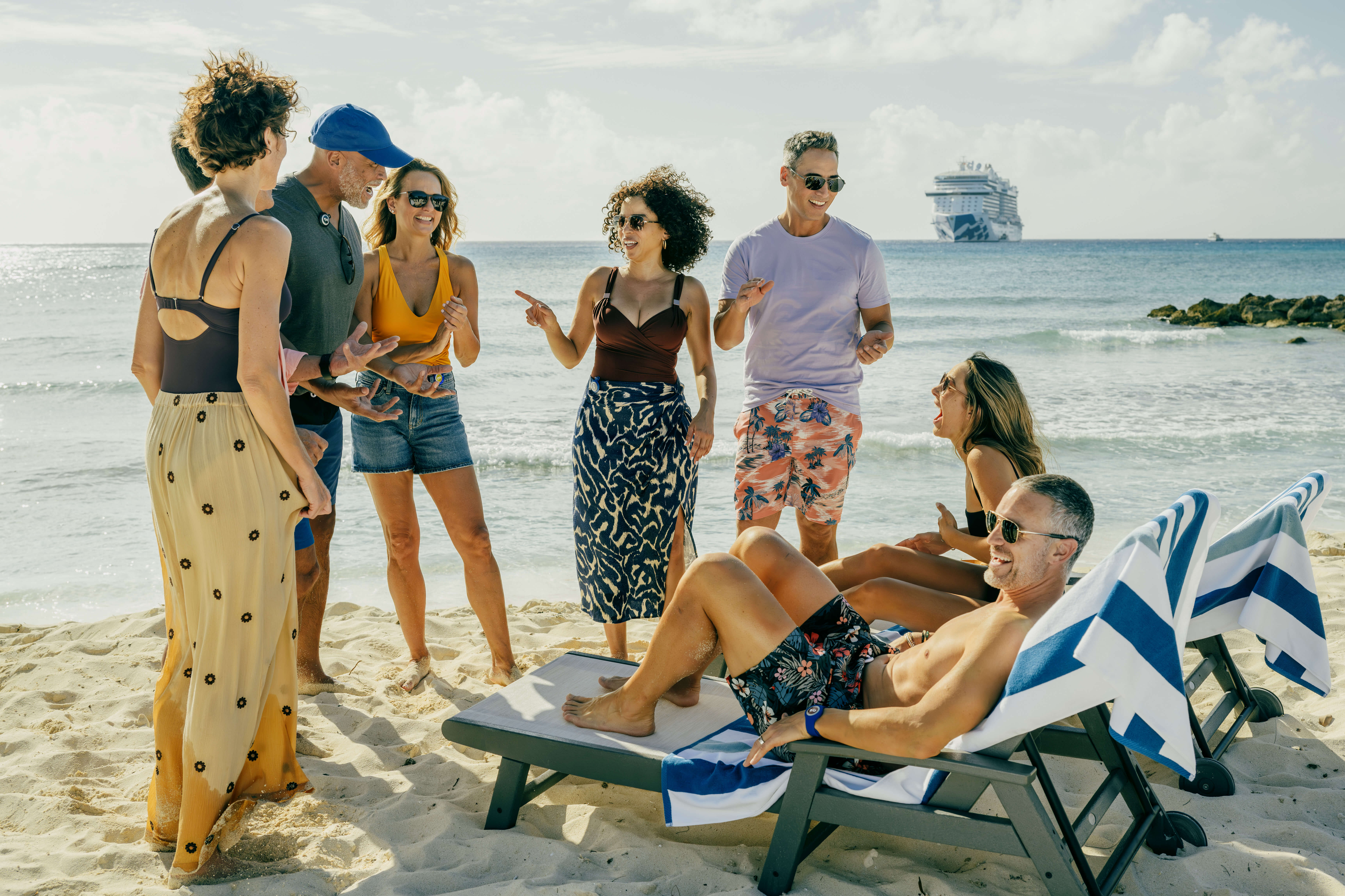 Group of people on beach, with cruise ship in background