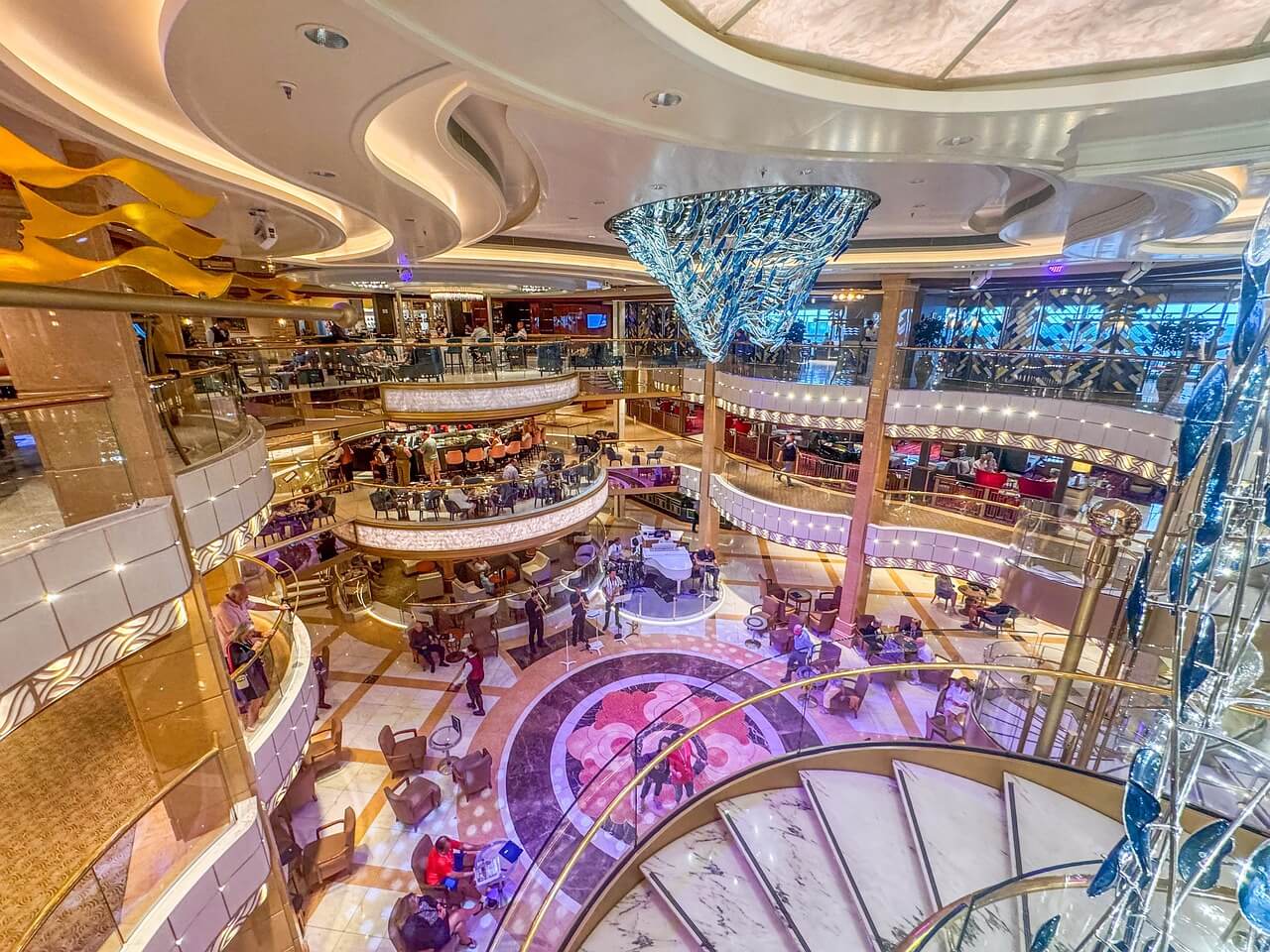 Cruise ship interior promenade with restaurants, shops, and onboard activity areas.